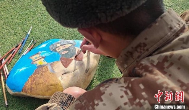 图为阿里军分区某边防团民族绘画队正在石头上绘画。 刘晓东 摄