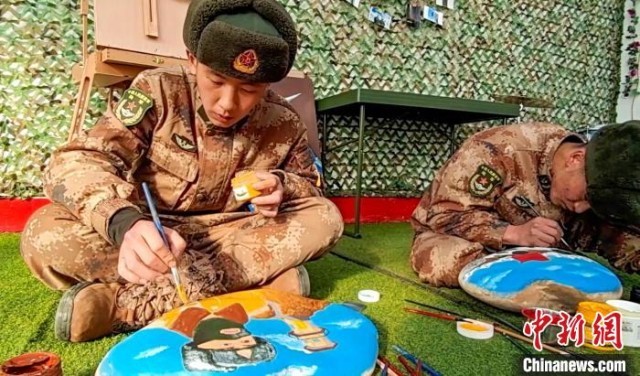 图为阿里军分区某边防团民族绘画队正在石头上绘画。 刘晓东 摄