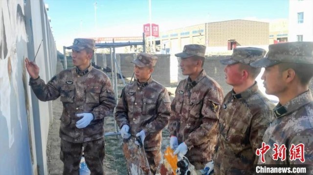 图为阿里军分区某边防团民族绘画队正在讨论墙绘需要注意的事项。 刘晓东 摄