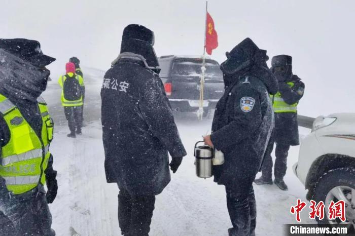 强降雪后,西藏安多县警方在国道109线唐古拉山段开展除雪保通工作.