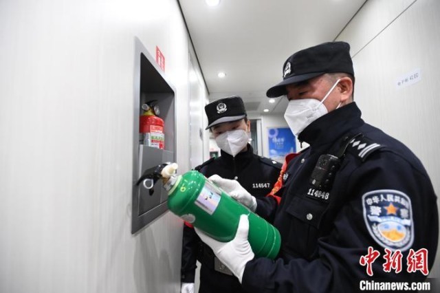 张金玉(右)和张婧煜在列车上进行消防安全检查。 安源 摄