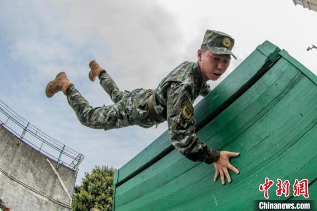 图为武警官兵在进行翻越高墙障碍训练。　余海洋 摄
