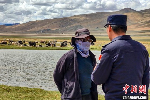 资料图为民警何宗源在公珠湖了解牧民情况。 龙小凤 摄